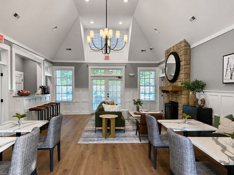 A dining room with a chandelier, a fireplace, and a mirror on the wall.