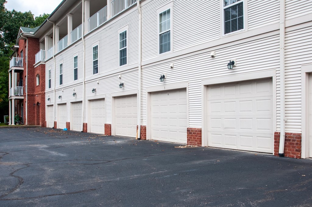 a row of white garage doors on the side of a building