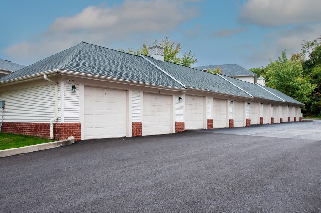a row of white garages with a gray roof