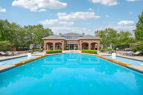 A large swimming pool in front of a house.