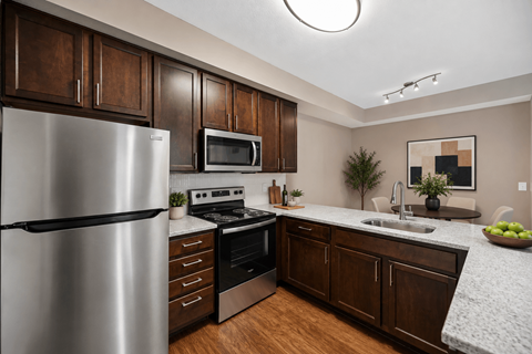 A modern kitchen with wooden cabinets and stainless steel appliances.