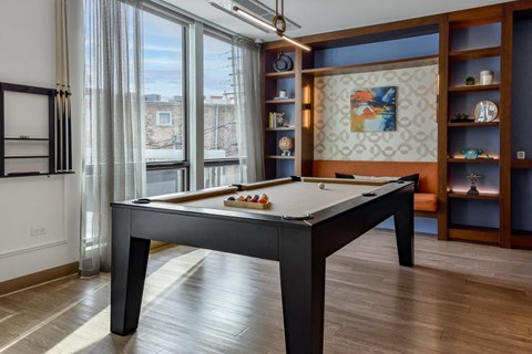 A pool table in a room with a view of the city.