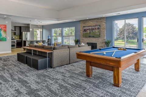 A pool table is in the middle of a living room.
