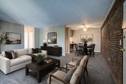 A living room with a white couch, a wooden coffee table, and a dining table with chairs.