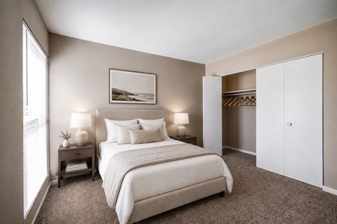 A bedroom with a large bed and a painting on the wall.