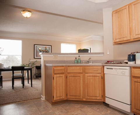 A kitchen with wooden cabinets and a white dishwasher.