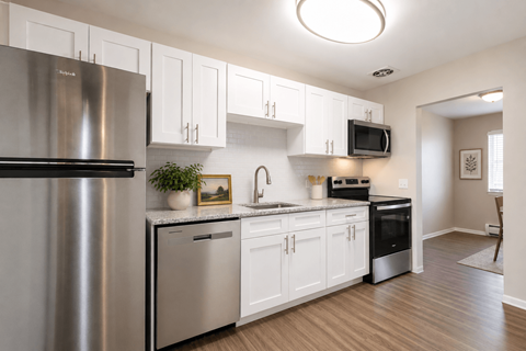 A modern kitchen with white cabinets and stainless steel appliances.