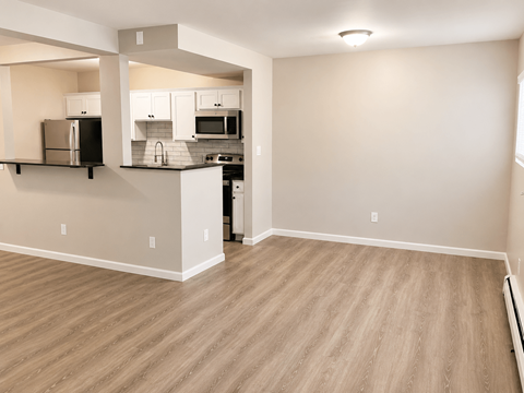 A kitchen with a refrigerator, microwave, and oven.