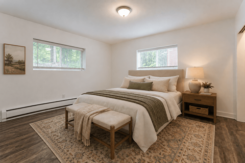A bedroom with a large bed and a bench in front of it.