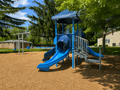 A playground with a blue slide and a blue roofed structure.