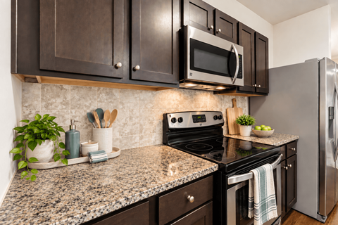 A kitchen with granite countertops and stainless steel appliances.