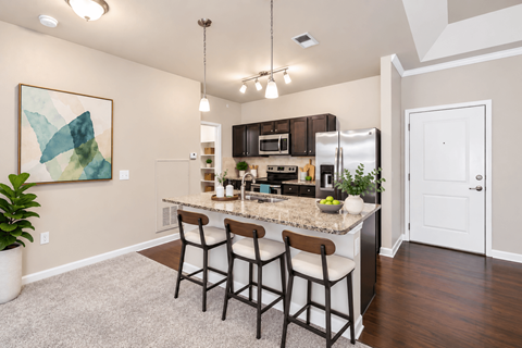 A kitchen with a bar area and a painting on the wall.