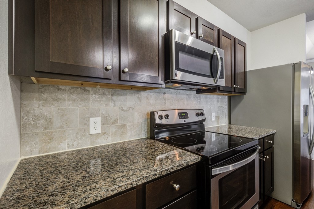 a kitchen with black appliances and granite counter tops