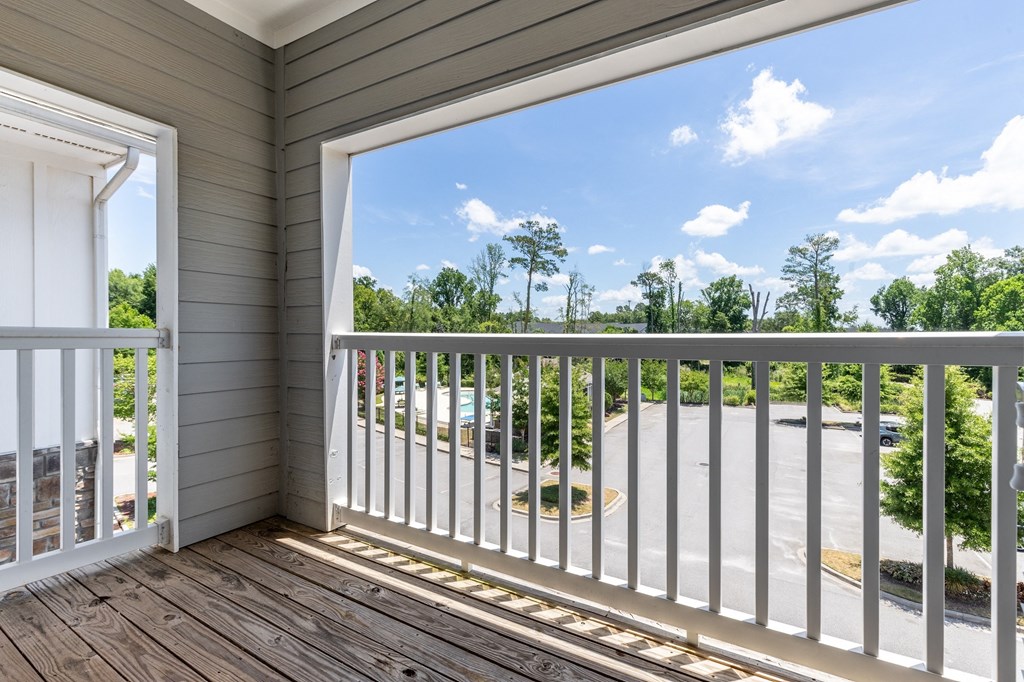 a view of a balcony with trees and a blue sky