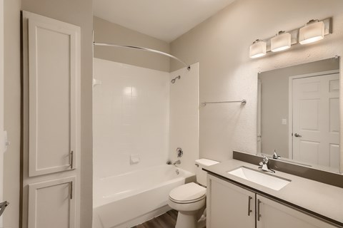 A white bathroom with a toilet, sink, and bathtub.