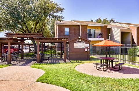 A park area with picnic tables and a playground.