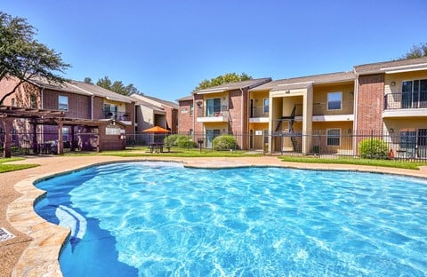 A swimming pool in front of apartment buildings.