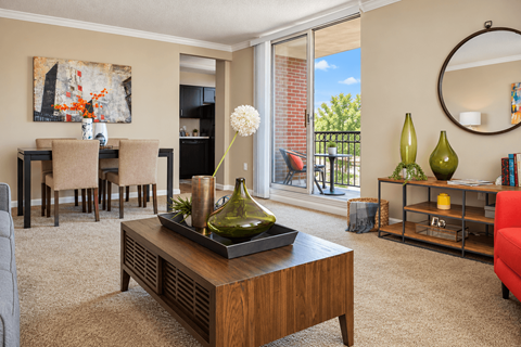 A living room with a brown coffee table and a painting on the wall.