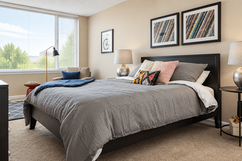A bedroom with a large bed and two framed pictures on the wall.