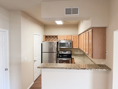 A kitchen with a refrigerator, oven, and microwave.
