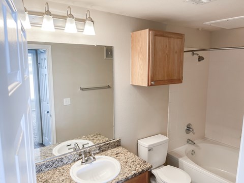 A bathroom with a sink, toilet, and bathtub.