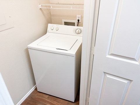 A white washing machine in a small laundry room.