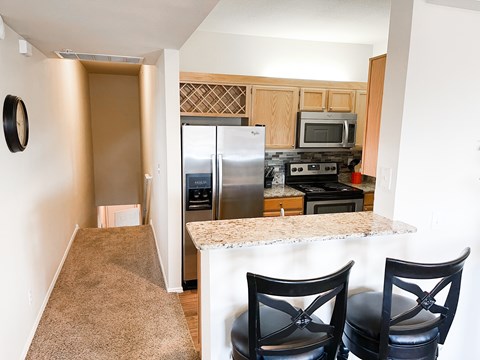 A kitchen with a refrigerator, oven, and microwave.