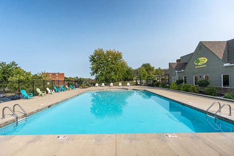 A large swimming pool with a clear blue water and sun loungers around it.