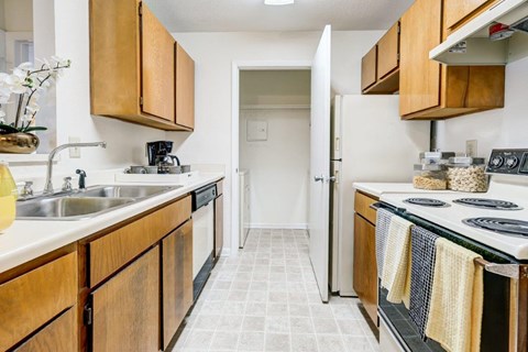 A kitchen with wooden cabinets and a white sink.