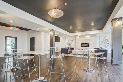 a communal space with tables and chairs and a living room with a fireplace