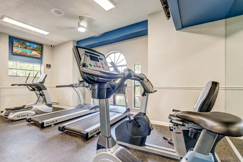 our apartments showcase a gym with equipment and a flat screen tv