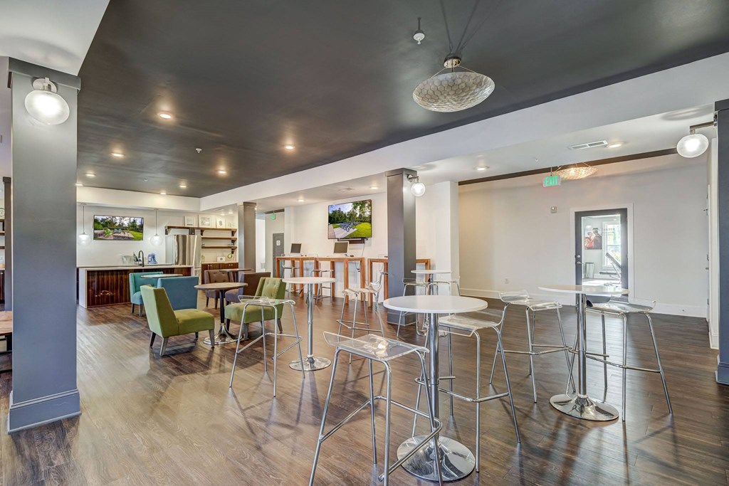 a common area with tables and chairs and a kitchen