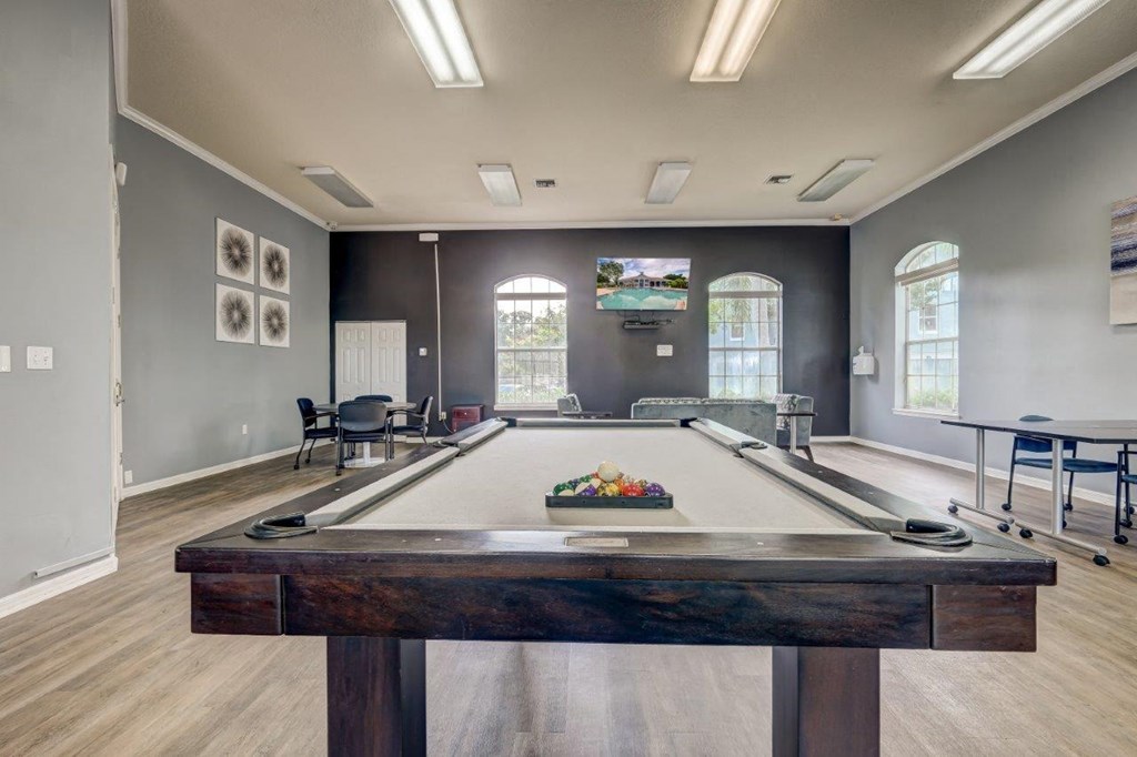 a games room with a pool table and a television