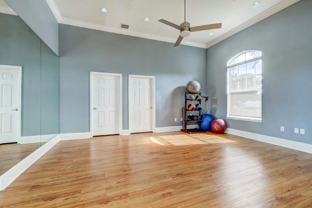 an empty living room with blue walls and a ceiling fan