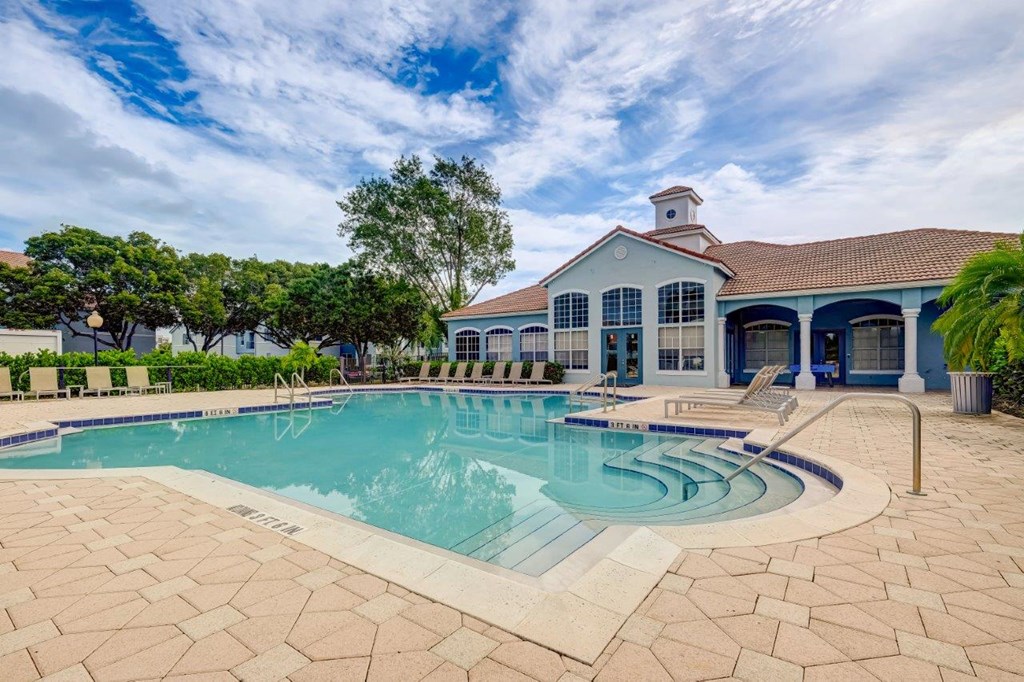 a large swimming pool with a house in the background