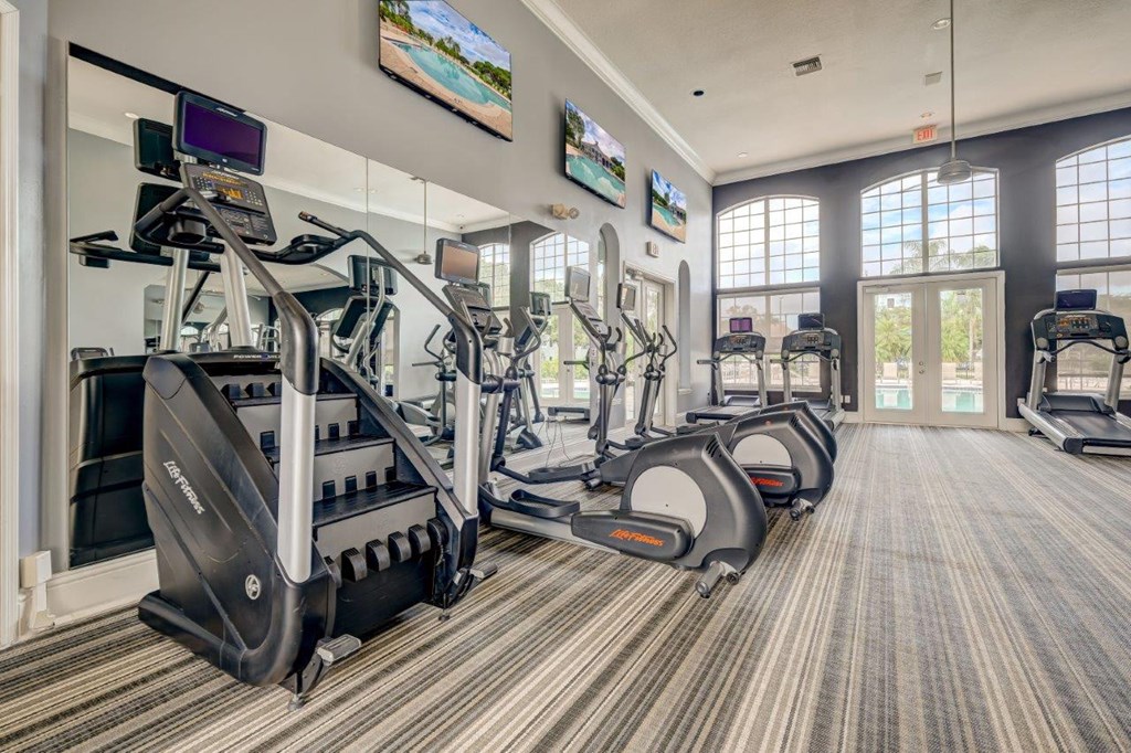 the gym in the clubhouse is equipped with cardio machines and televisions