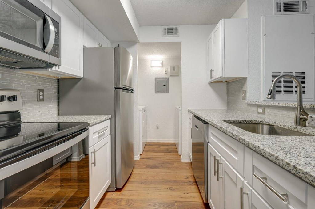 a kitchen with white cabinets and stainless steel appliances