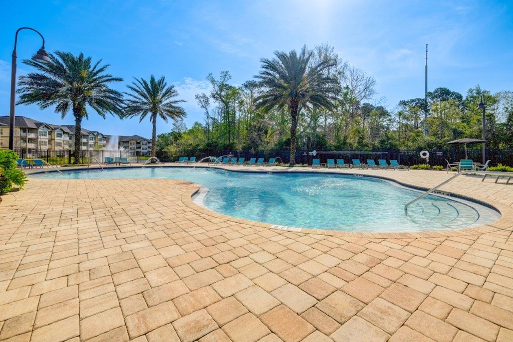 a swimming pool with palm trees in the background