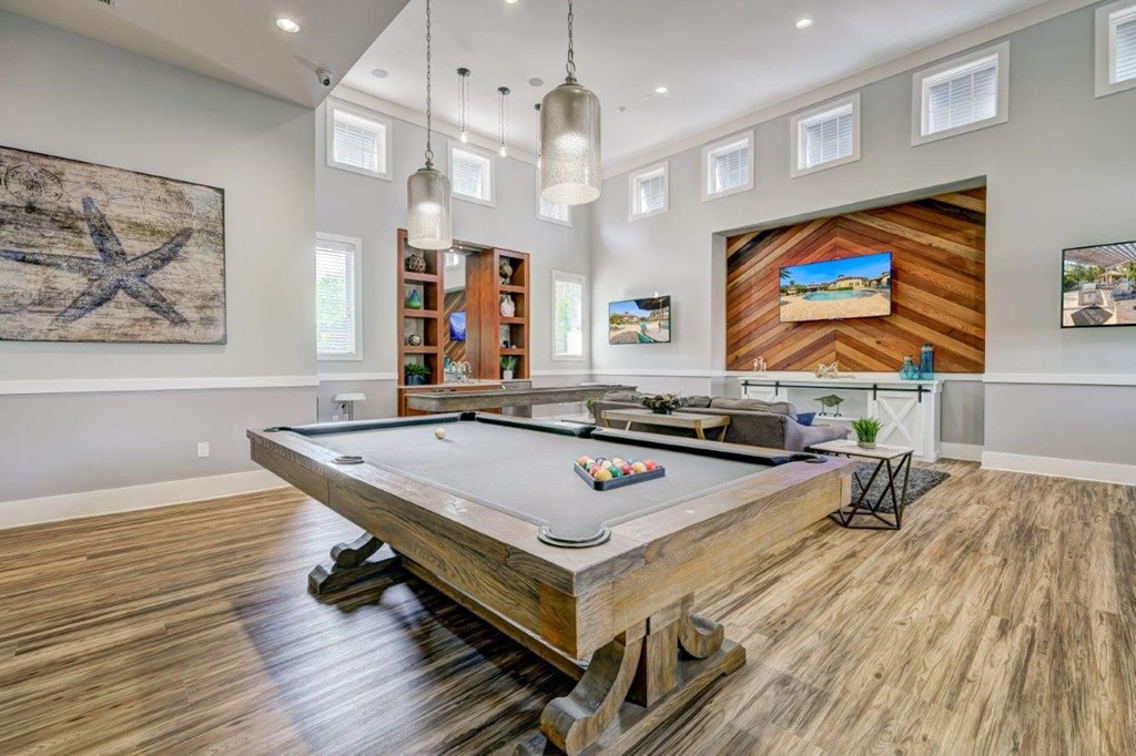 a game room with a pool table and a bar