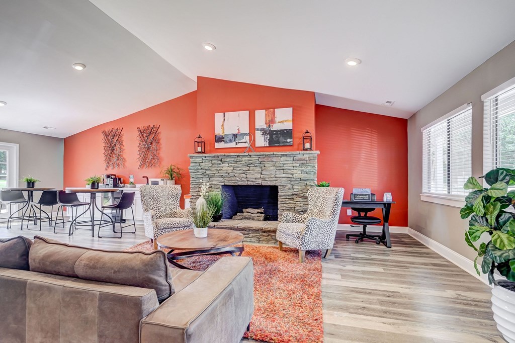 a living room with orange walls and a stone fireplace