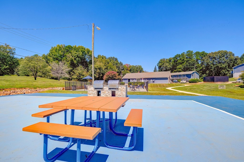 the picnic tables on the roof of the basketball court are equipped with benches