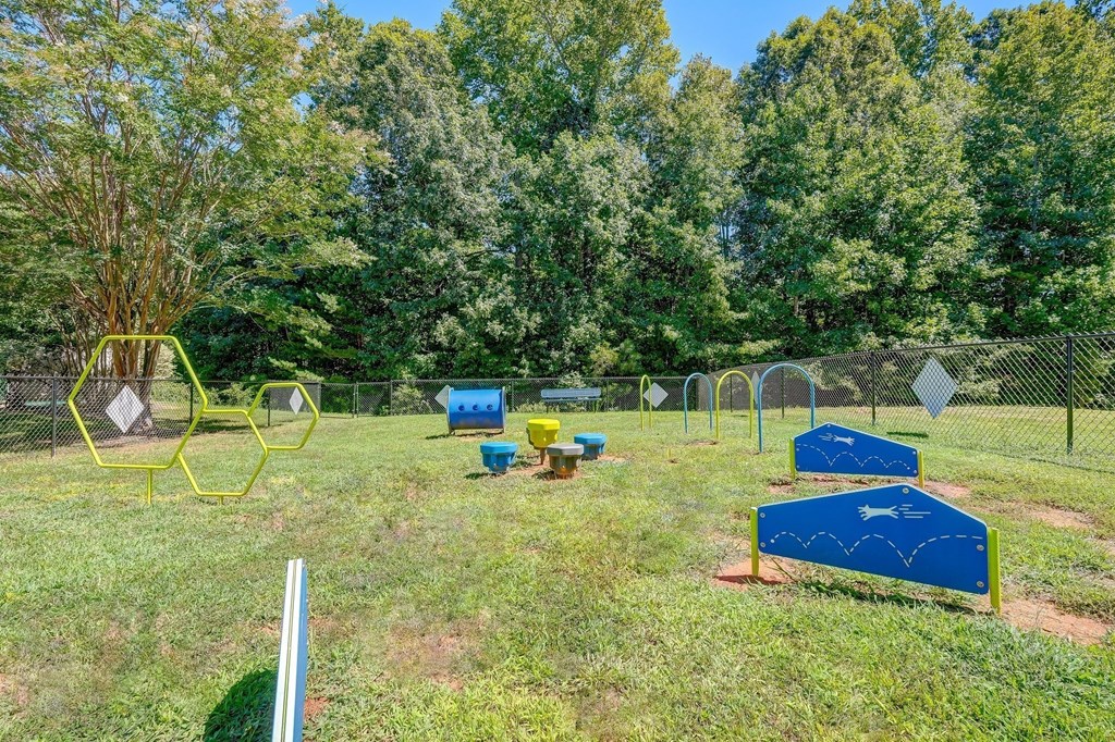 a park with a playground and a chain link fence