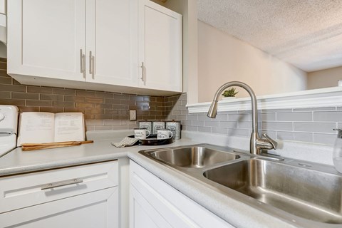 a kitchen with a sink and white cabinets