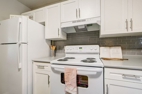 a kitchen with white appliances and white cabinets