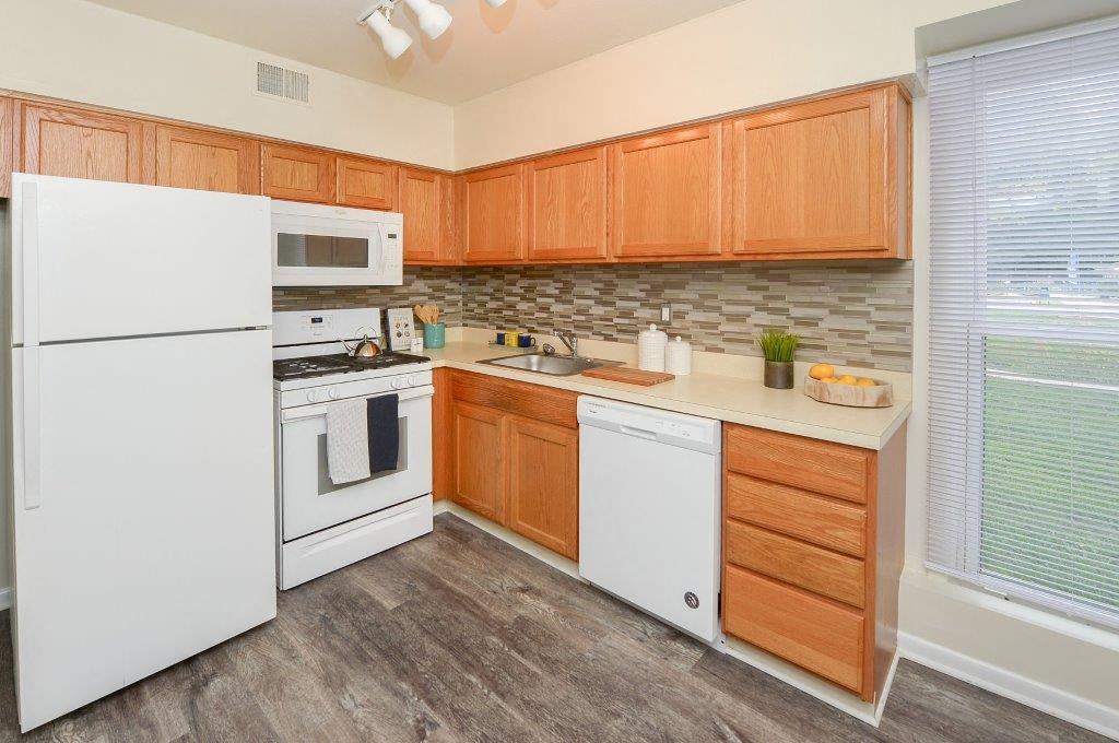 a kitchen with white appliances and wooden cabinets