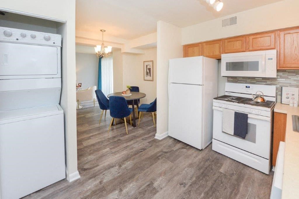 a kitchen with white appliances and a dining room with a table