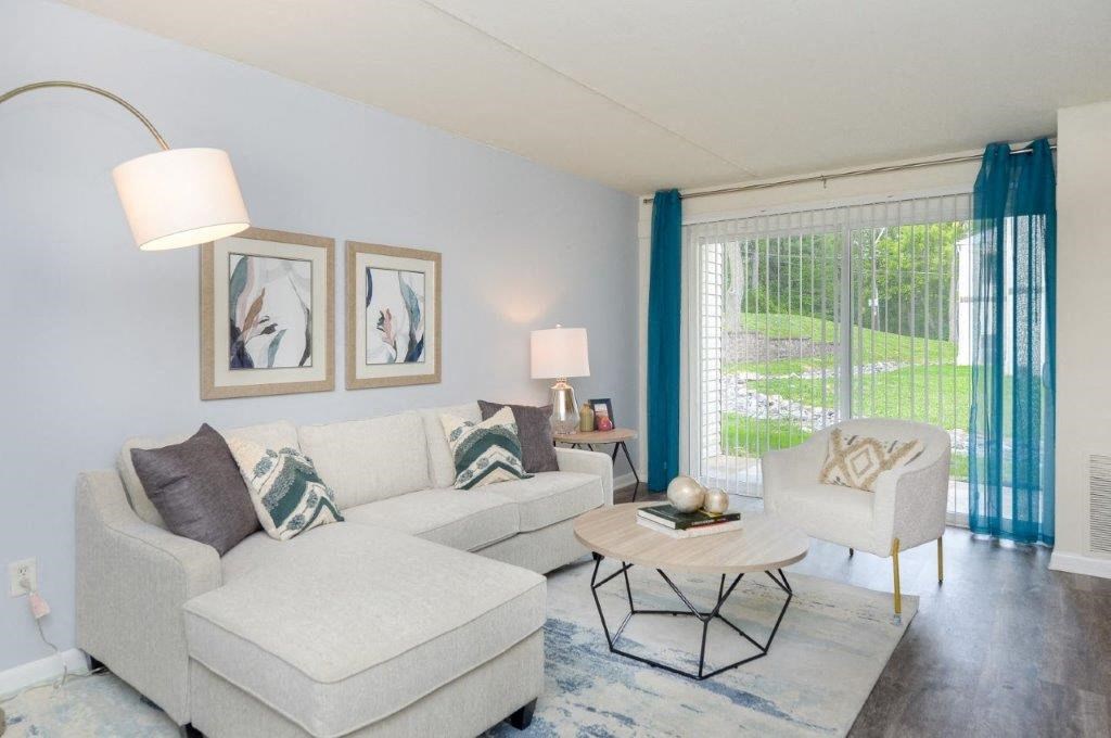 a living room with couches and chairs and a large window