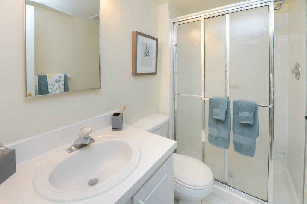 a white bathroom with a shower and a sink