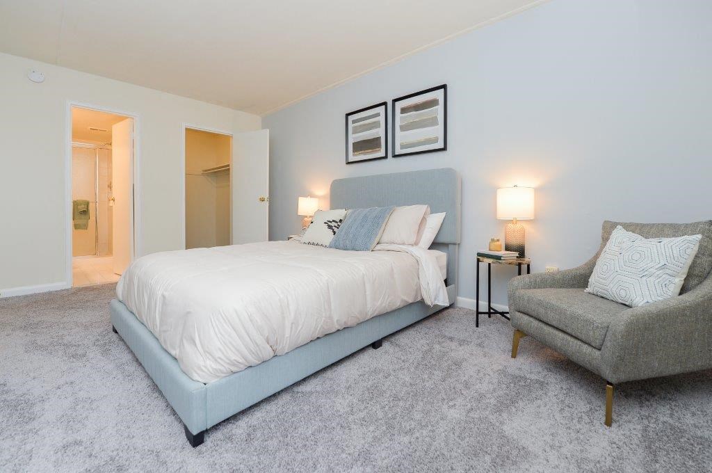 a blue and white bedroom with a bed and a chair
