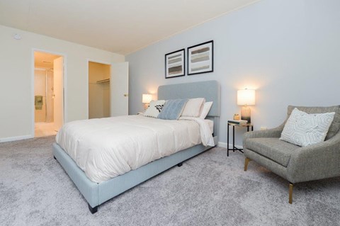 a blue and white bedroom with a bed and a chair